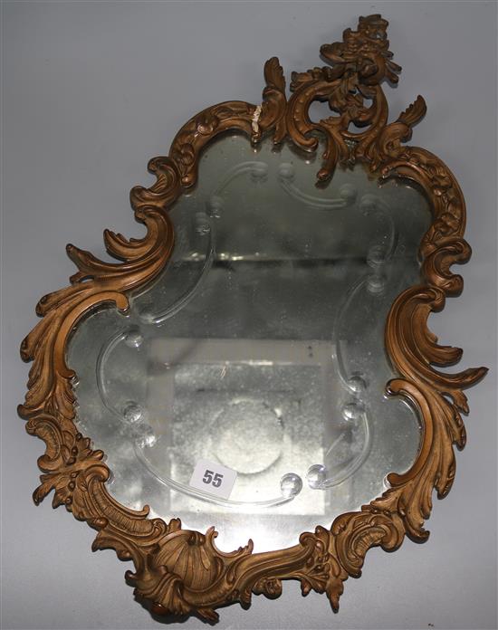 A pair of ornate ormolu shaped wall mirrors